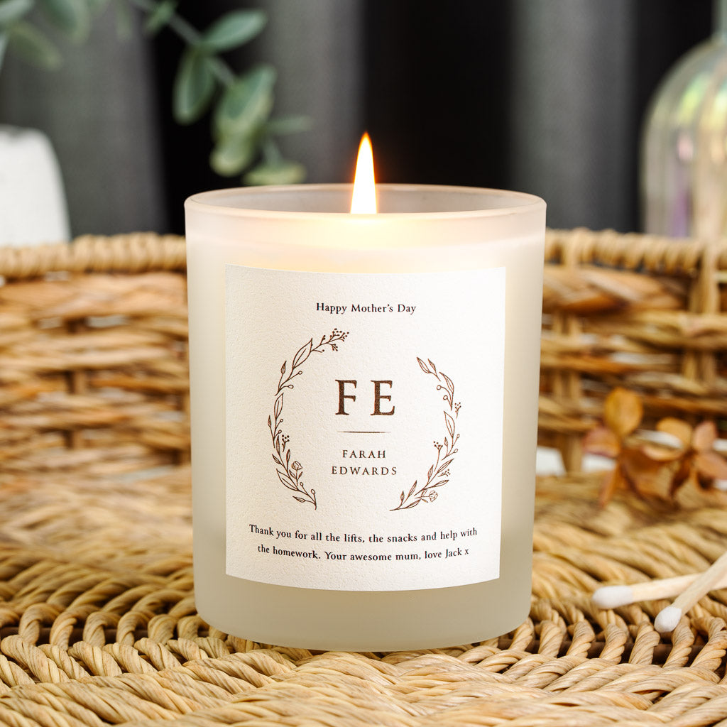 Warm brown line wreath curving around a monogram on a personalised Mother's Day candle
