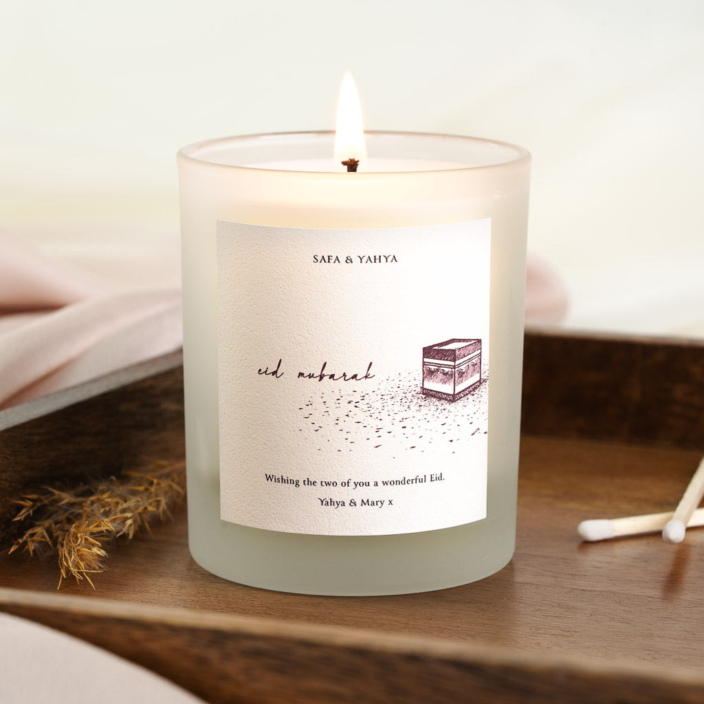 Hand-sketched Kaaba in maroon ink with a scattered dot texture on a personalised Eid candle