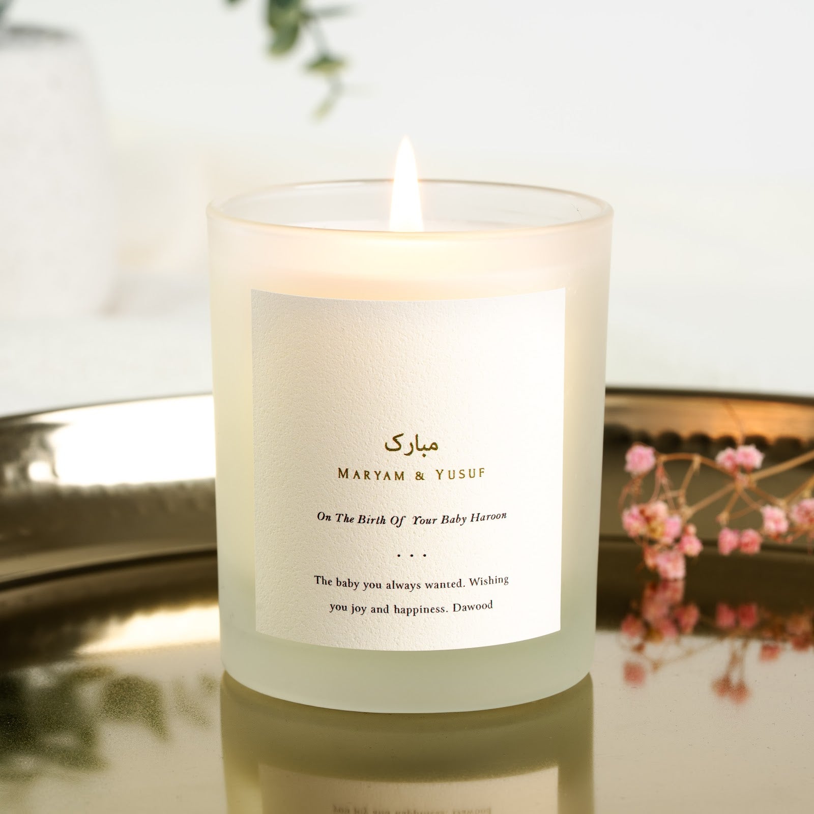 Personalised Islamic new baby candle with gold-toned Arabic script above the parents' names