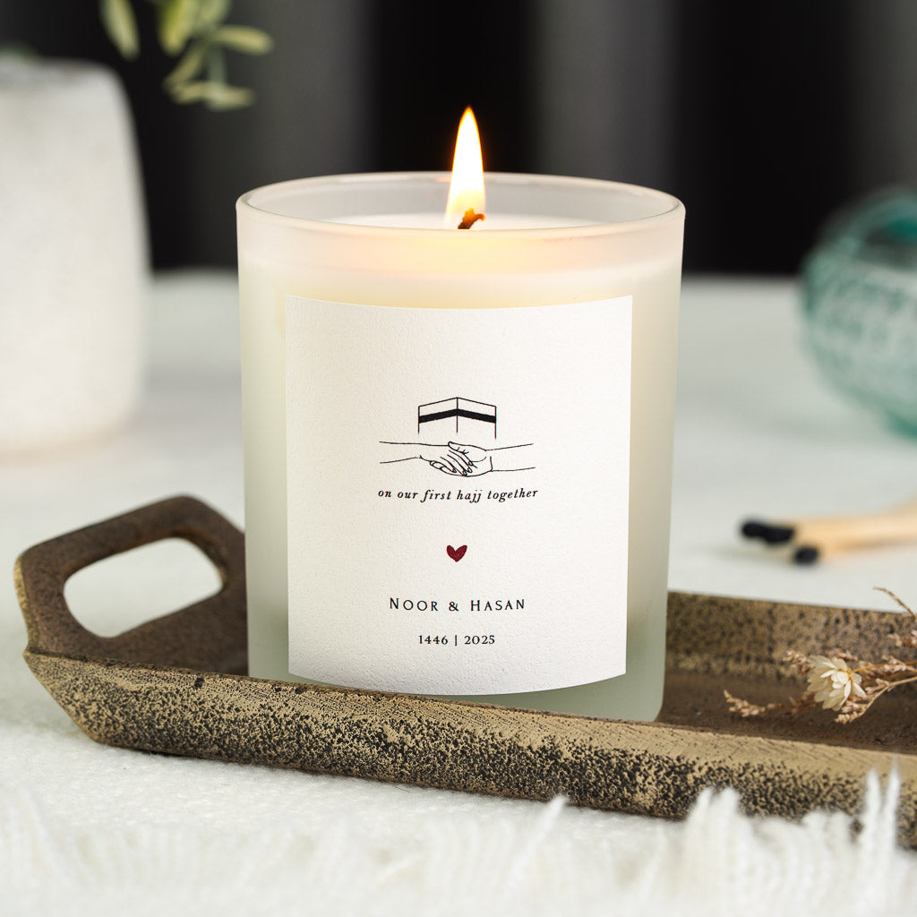 Personalised Hajj candle with a minimal Kaaba and joined hands above a script message