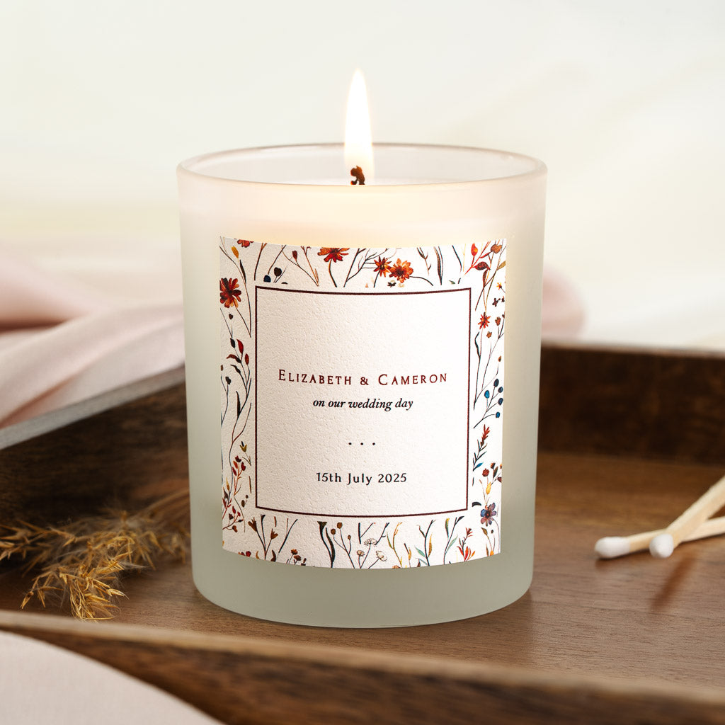 Autumnal rust and burgundy wildflowers around a bordered panel on a personalised wedding candle