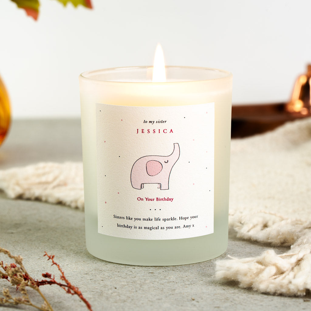 Personalised birthday candle with red capitals beside a small elephant illustration