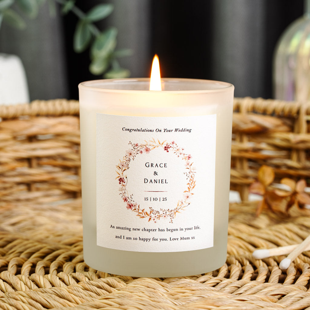 Pink flower and gold foliage wreath encircling the names on a personalised wedding candle