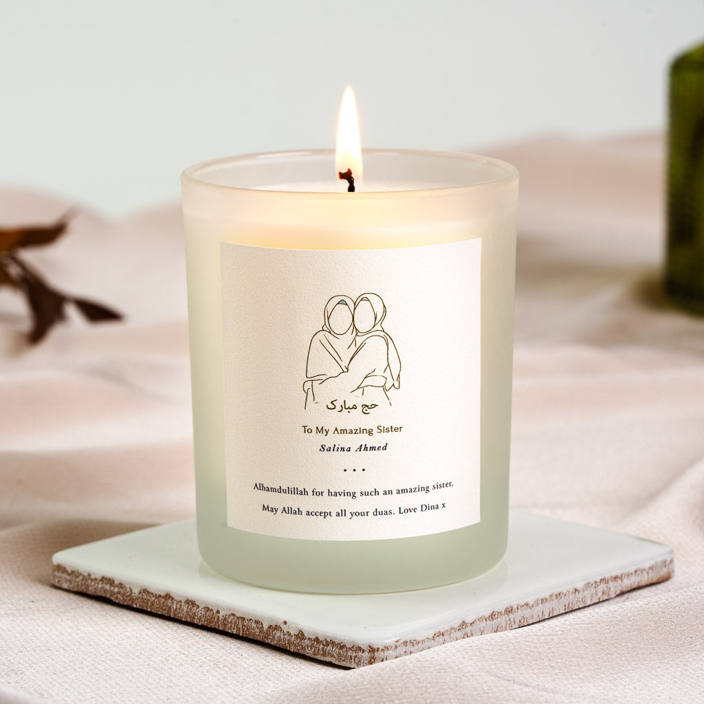 Personalised Hajj candle with two embracing figures above Arabic calligraphy