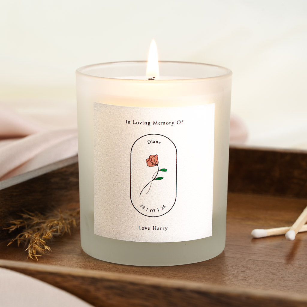 Personalised memorial candle with a coral-toned flower inside a central oval outline