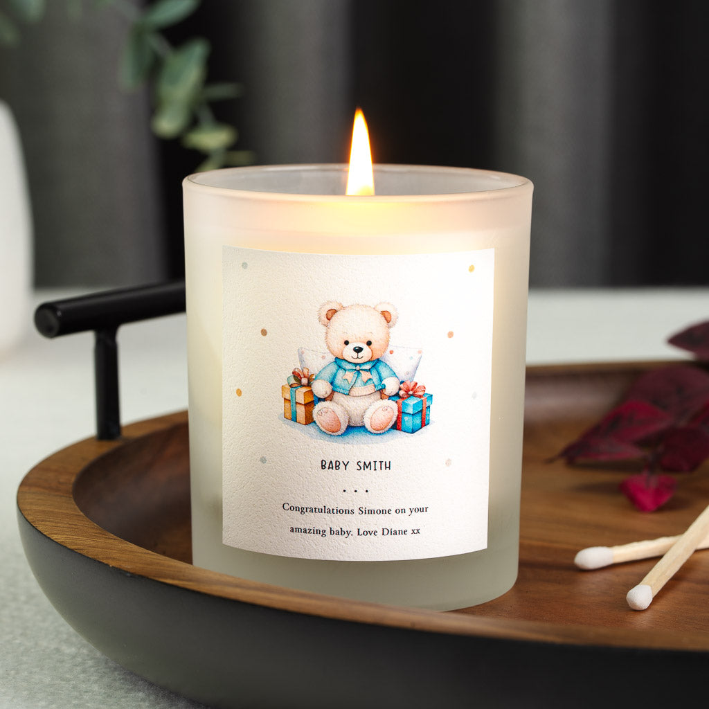 Illustrated bear surrounded by wrapped gifts on a personalised new baby candle label