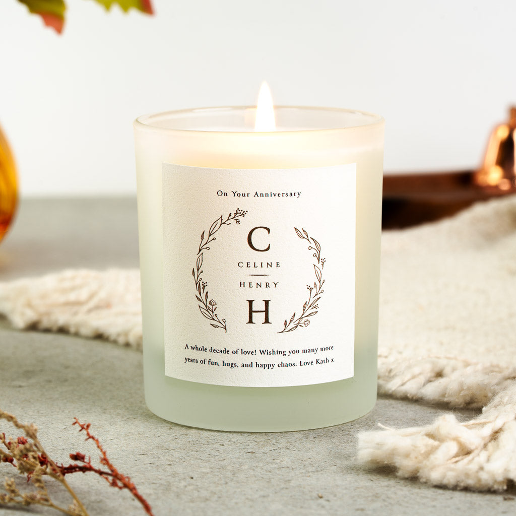 Monogram wreath framing the couple's initials on a personalised anniversary candle label