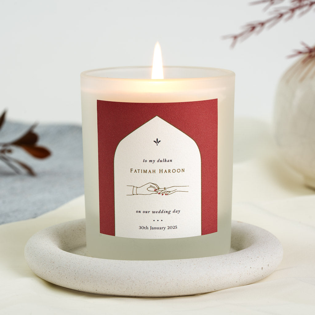 Personalised wedding candle with a white arch on rust red holding a line drawing of a hand