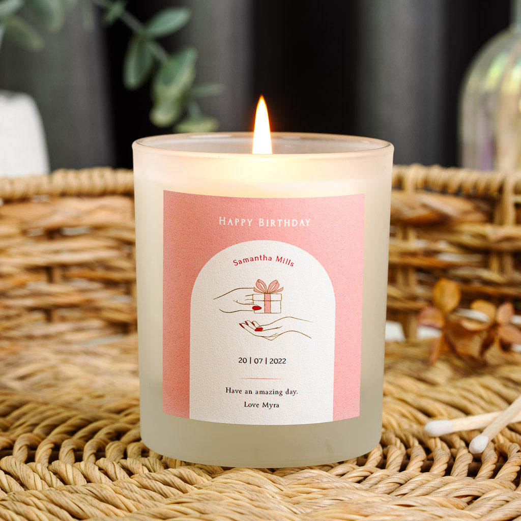 Personalised birthday candle with a hand illustration inside a white arch on solid pink