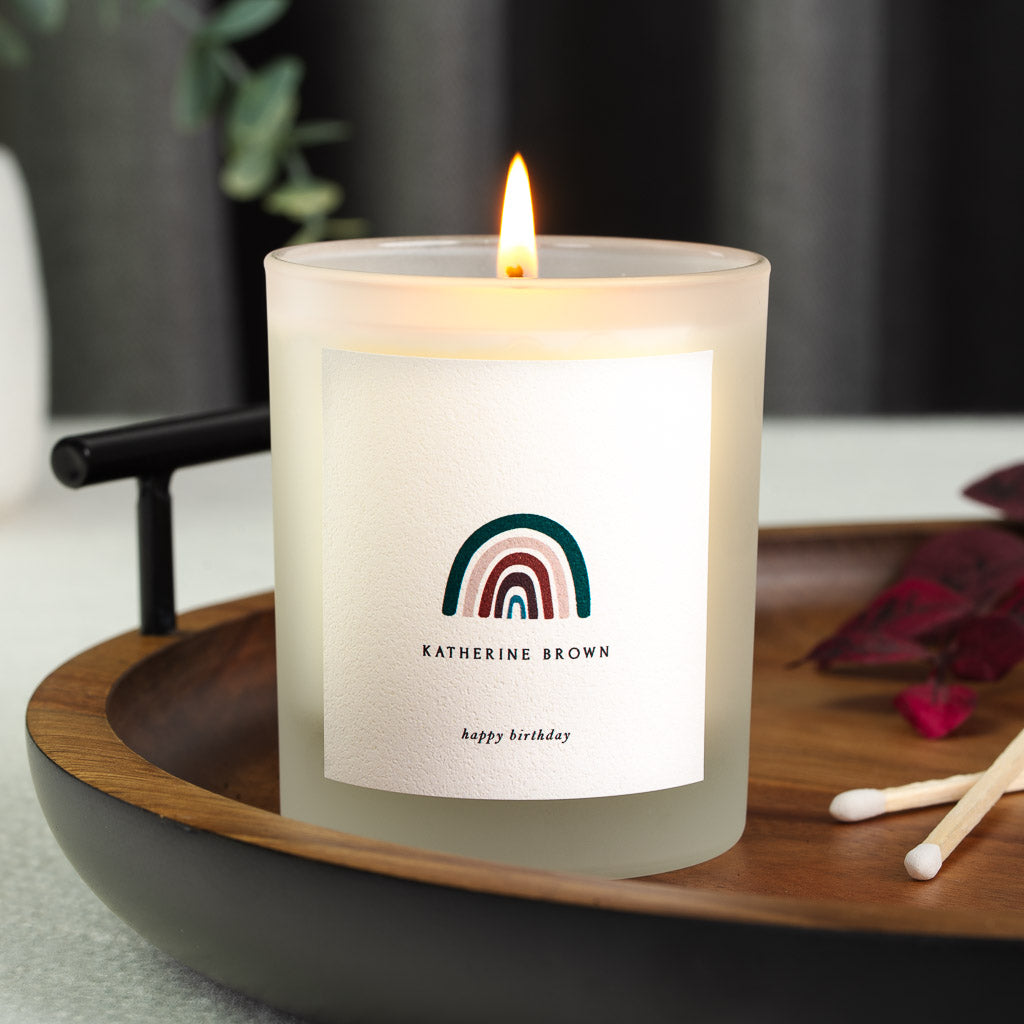 Personalised birthday candle with a simple rainbow illustration above the name