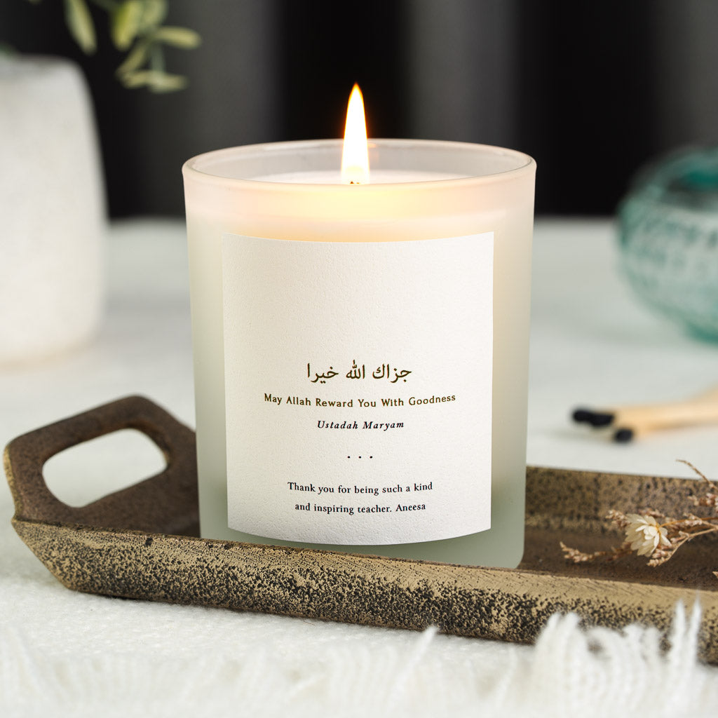 Gold-toned Arabic script above its English translation on a personalised teacher candle