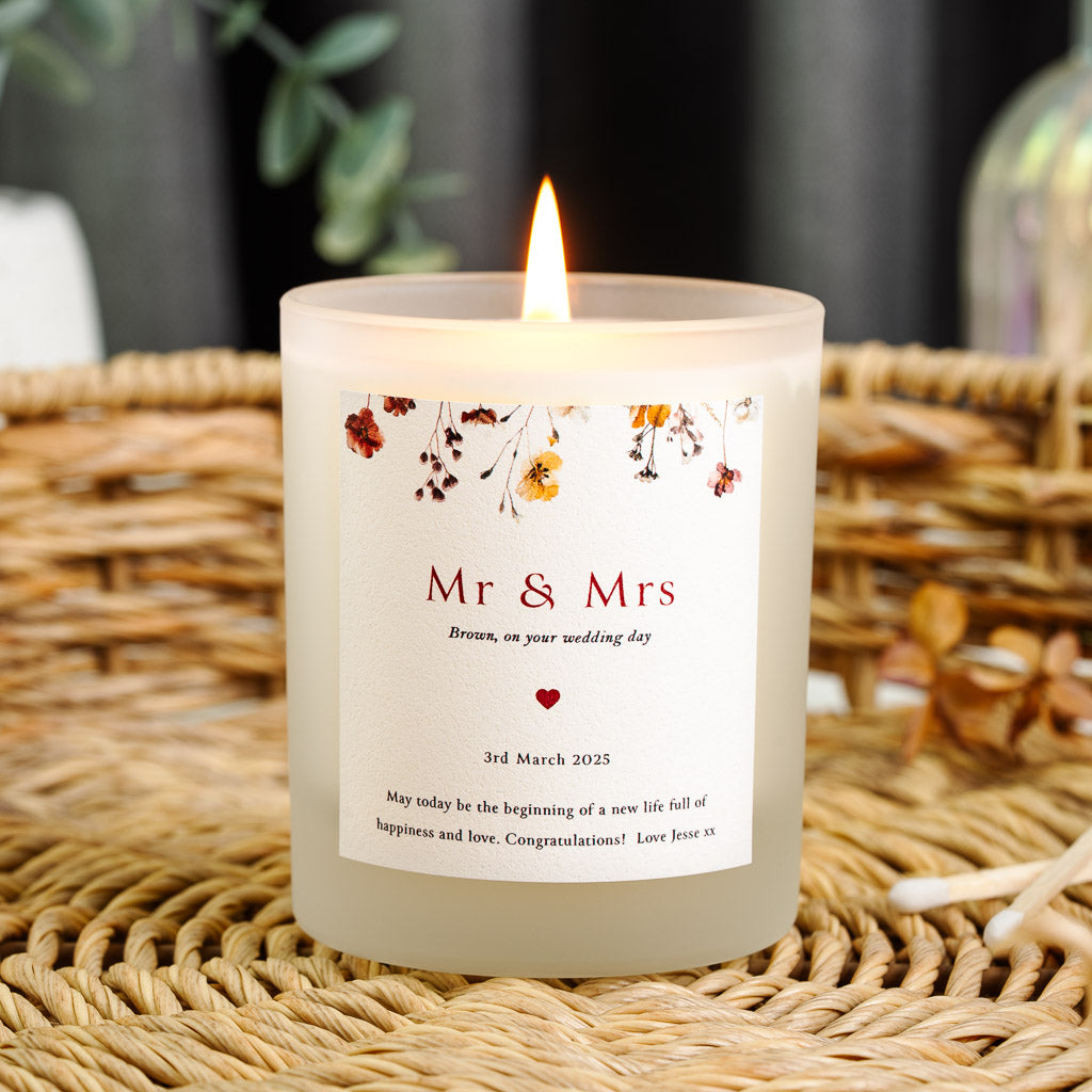 Pressed red and blush flowers above Mr and Mrs in red serif on a personalised wedding candle