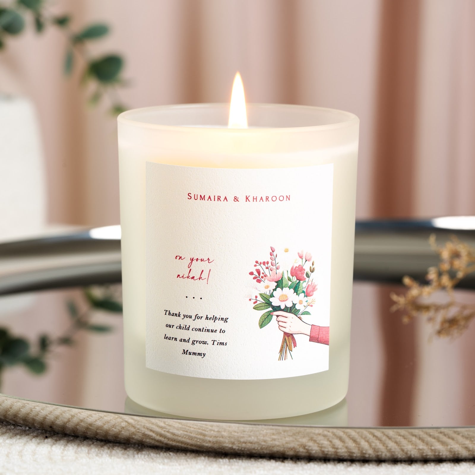 Names in red script above a hand-lettered nikah line on a personalised candle label