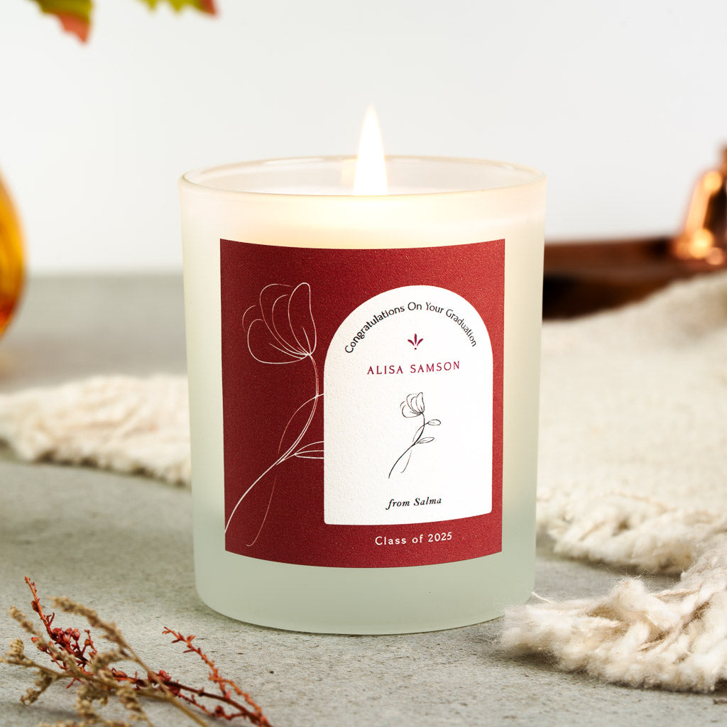Fine white line flowers trailing down a deep red personalised graduation candle label