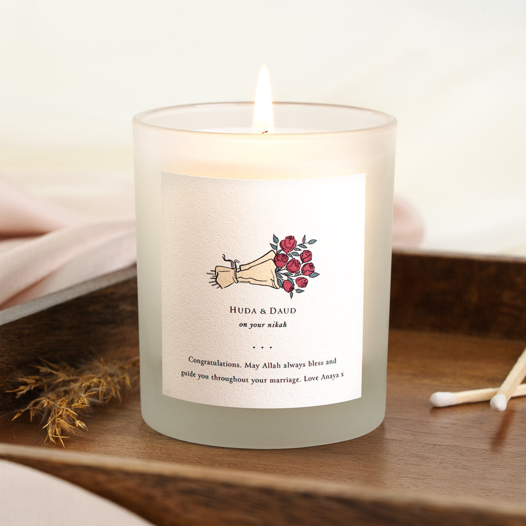 Illustrated hand extending a bouquet of red roses on a personalised nikah candle label