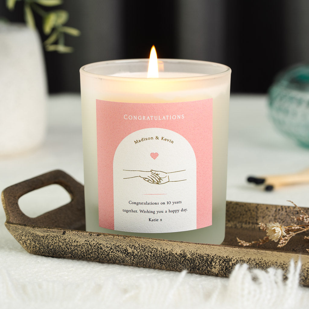 Hand-in-hand illustration on a white panel on a personalised anniversary candle