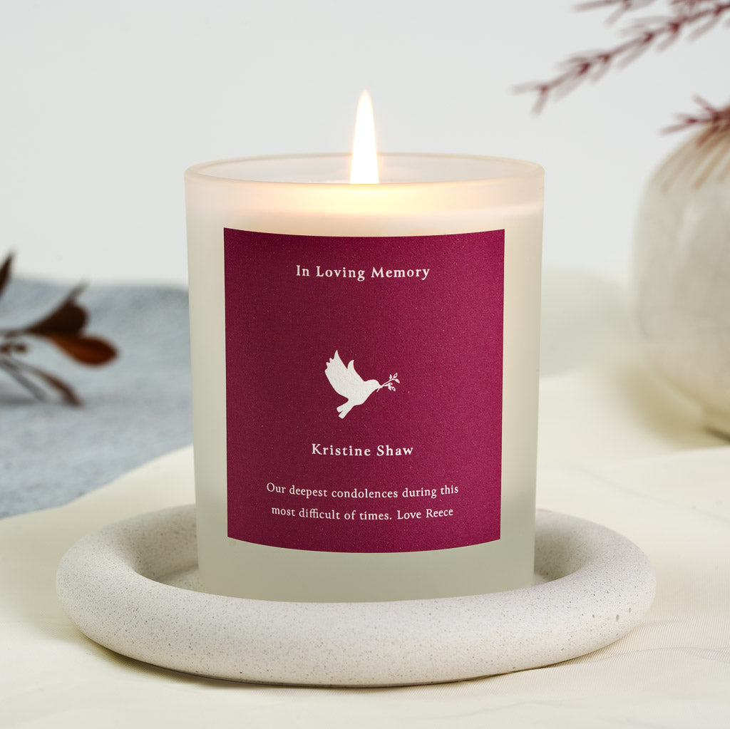 Personalised memorial candle with a dove illustration above the name