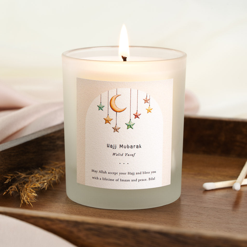 Personalised Hajj candle with a watercolour moon and hanging stars beneath an arched panel