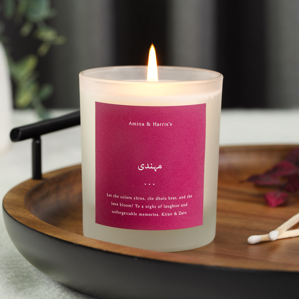 Names in white capitals on a solid magenta personalised mehndi candle label