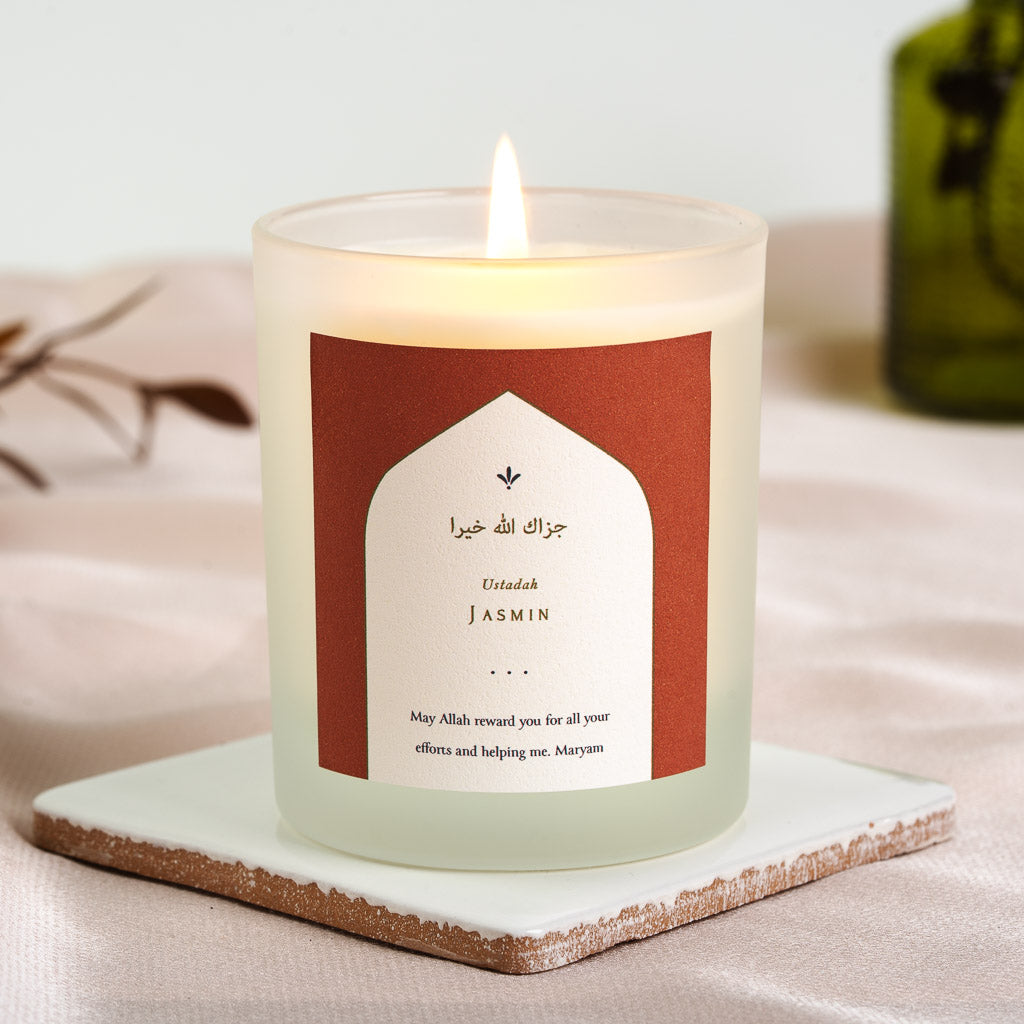 White arch on deep terracotta holding Arabic script on a personalised teacher candle