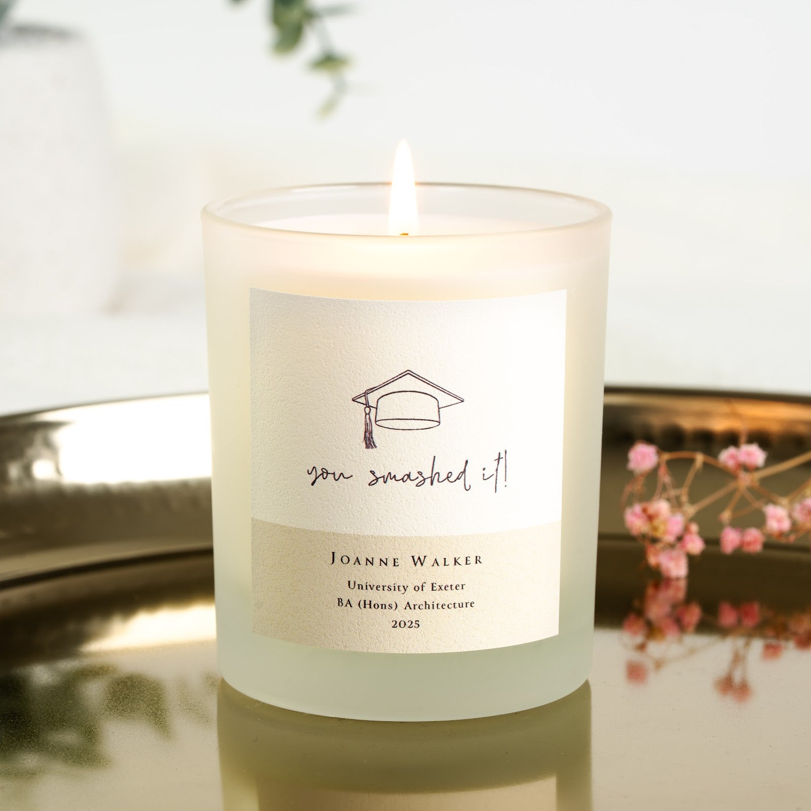 Personalised graduation candle with a line-drawn cap above handwritten-style lettering