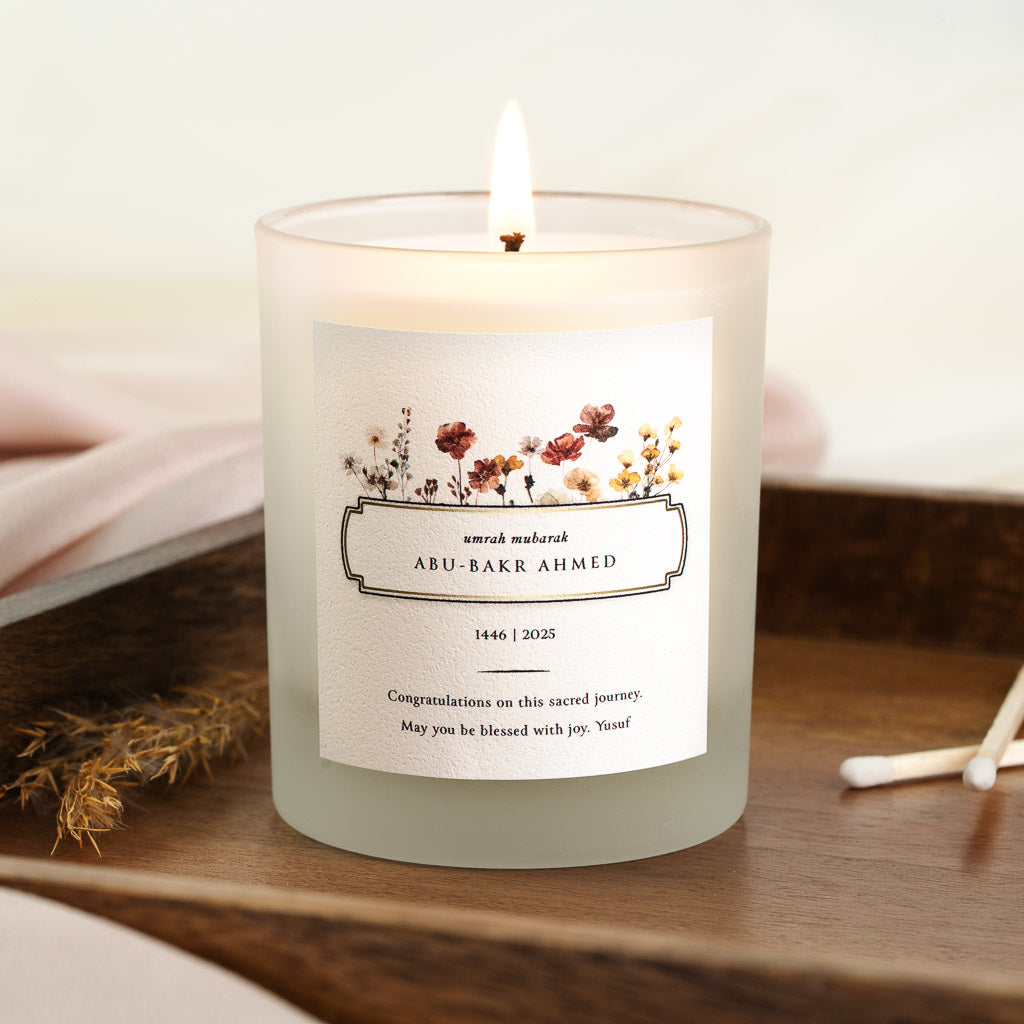 Wildflowers framing a boxed umrah mubarak panel on a personalised Umrah candle label