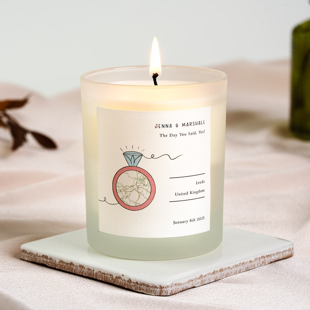 Ring illustration beside the personalised location and date on an engagement candle