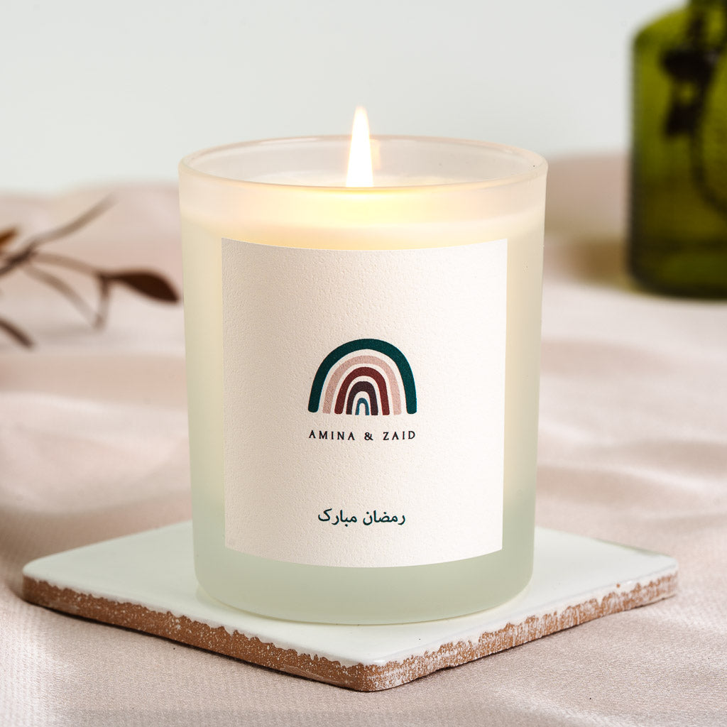 Muted watercolour rainbow in teal, blush and burgundy on a personalised Ramadan candle