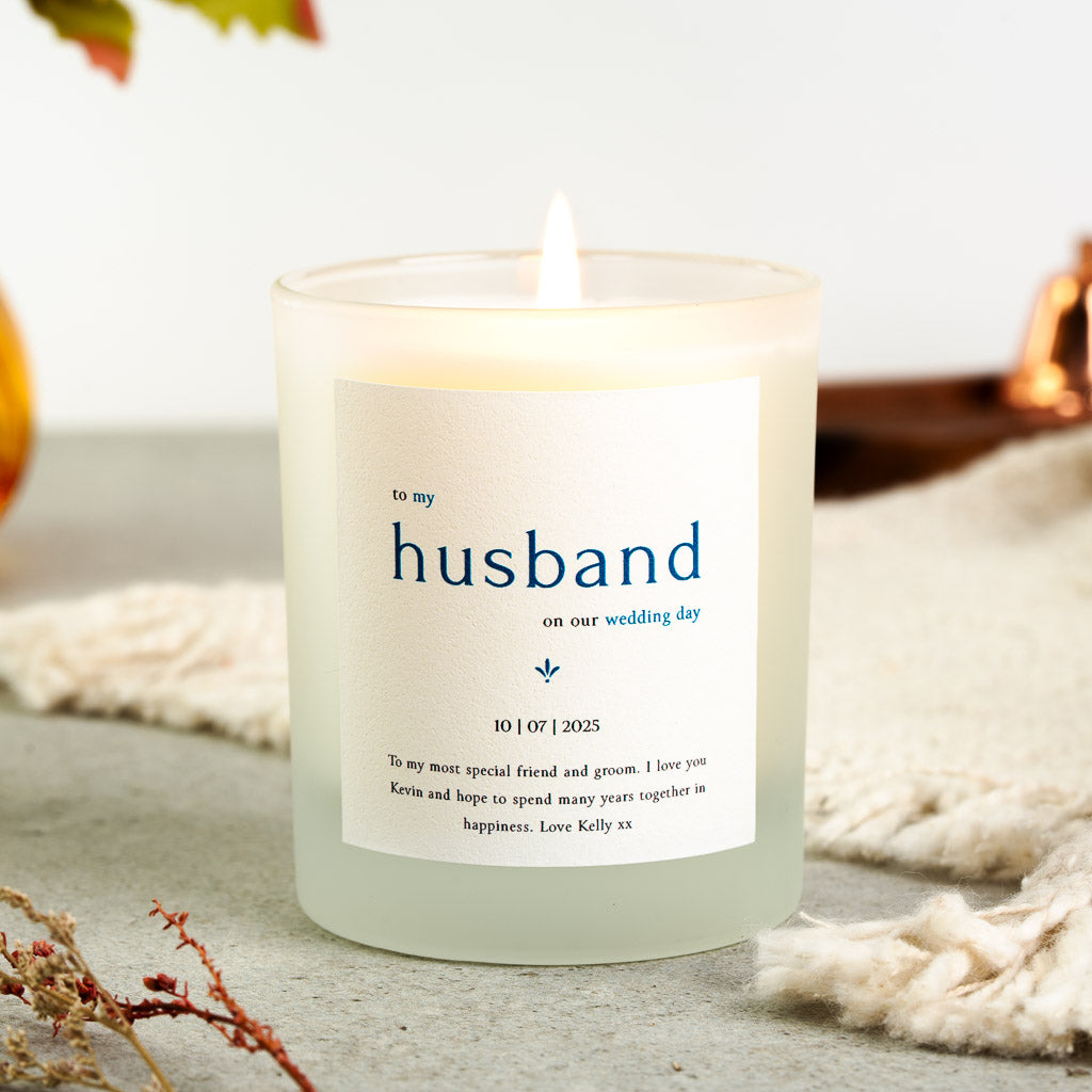 The word husband in large blue capitals on a personalised wedding day candle label