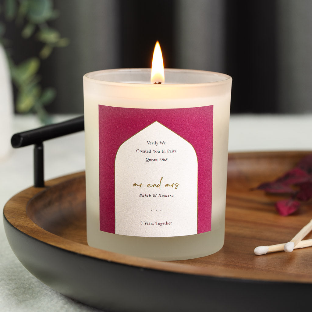 Personalised anniversary candle with a Quran verse inside a white arch on deep berry