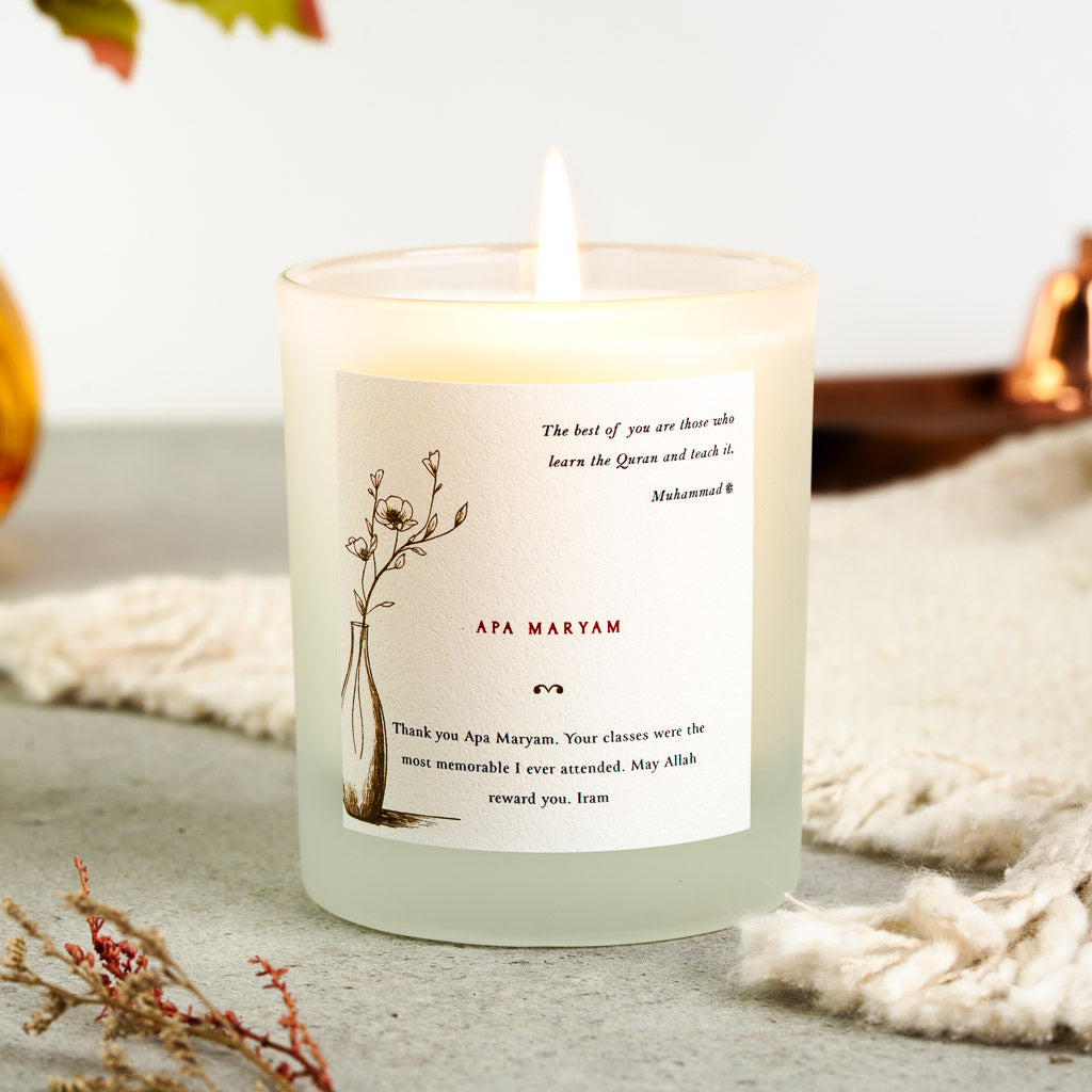 Flowering branch in a vase beside a hadith on a personalised Quran teacher candle