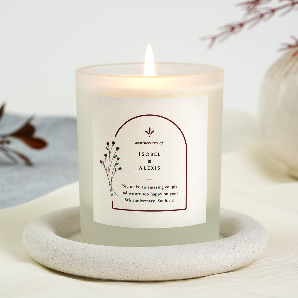 Personalised anniversary candle with the names centred inside an arch above a thin rule