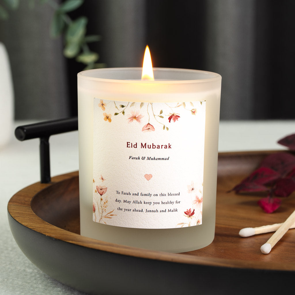 Watercolour pink, peach and red wildflowers framing a personalised Eid candle label