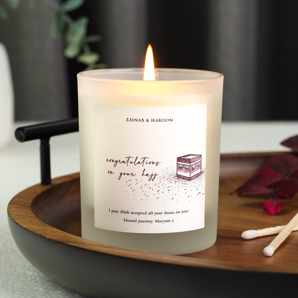 Personalised Hajj candle with the Kaaba sketched in warm burgundy ink beneath the names