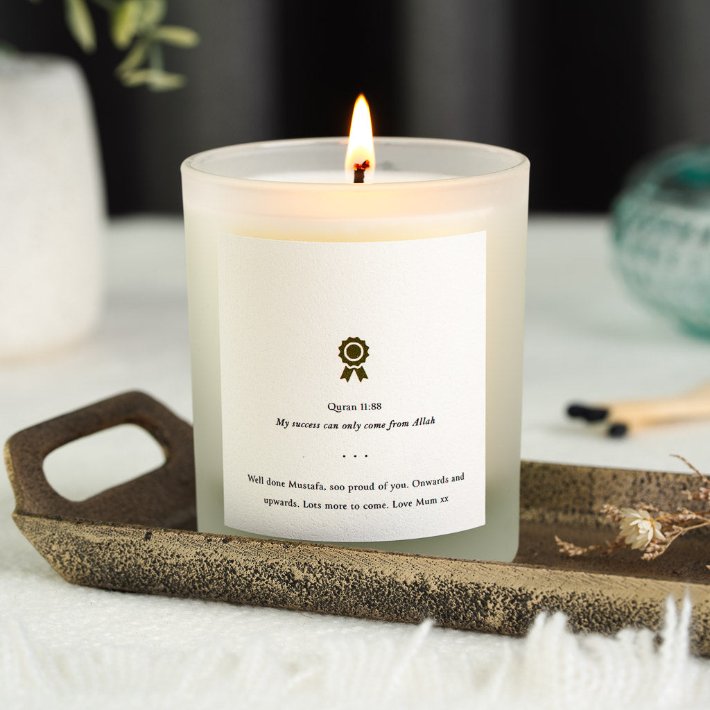 Small award ribbon icon above Surah Hud on a personalised graduation candle