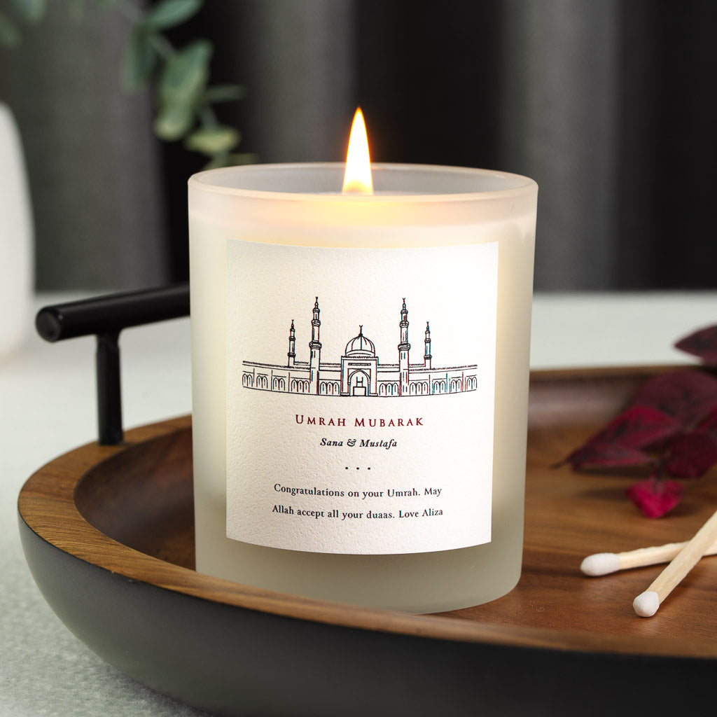 Personalised Umrah candle with a masjid illustration above the greeting in red