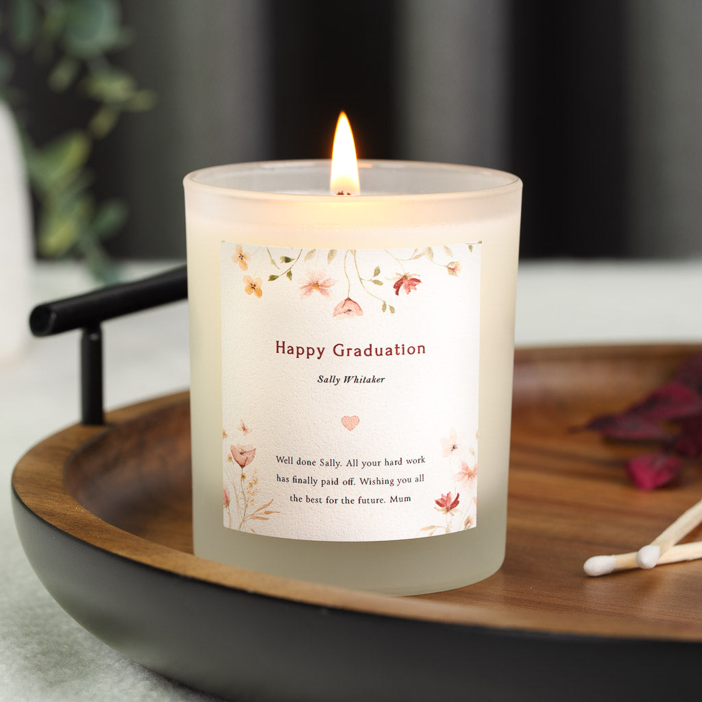 Personalised graduation candle with dusty pink and gold pressed flowers in the corners