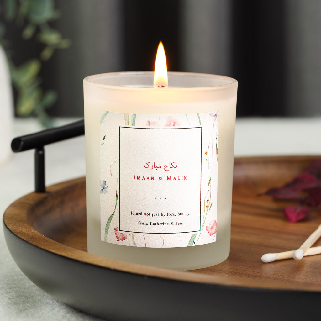Pink and green pressed florals bordering a thin black panel on a personalised nikah candle