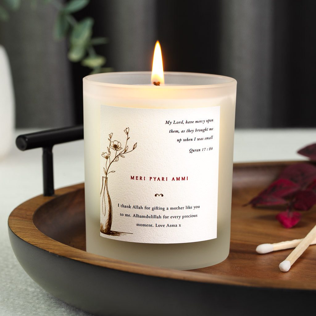 Flowering branch in a vase beside Surah Al-Isra on a personalised Islamic Mother's Day candle
