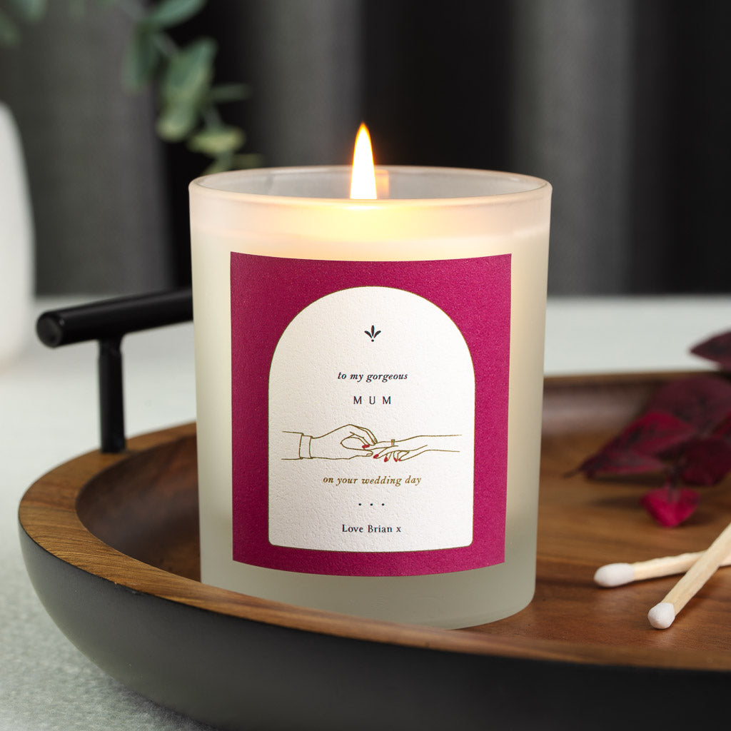 Personalised wedding candle with a ring illustration inside a white arch on magenta