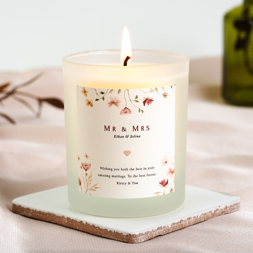 Trailing wildflowers framing Mr and Mrs in bold serif on a personalised wedding candle