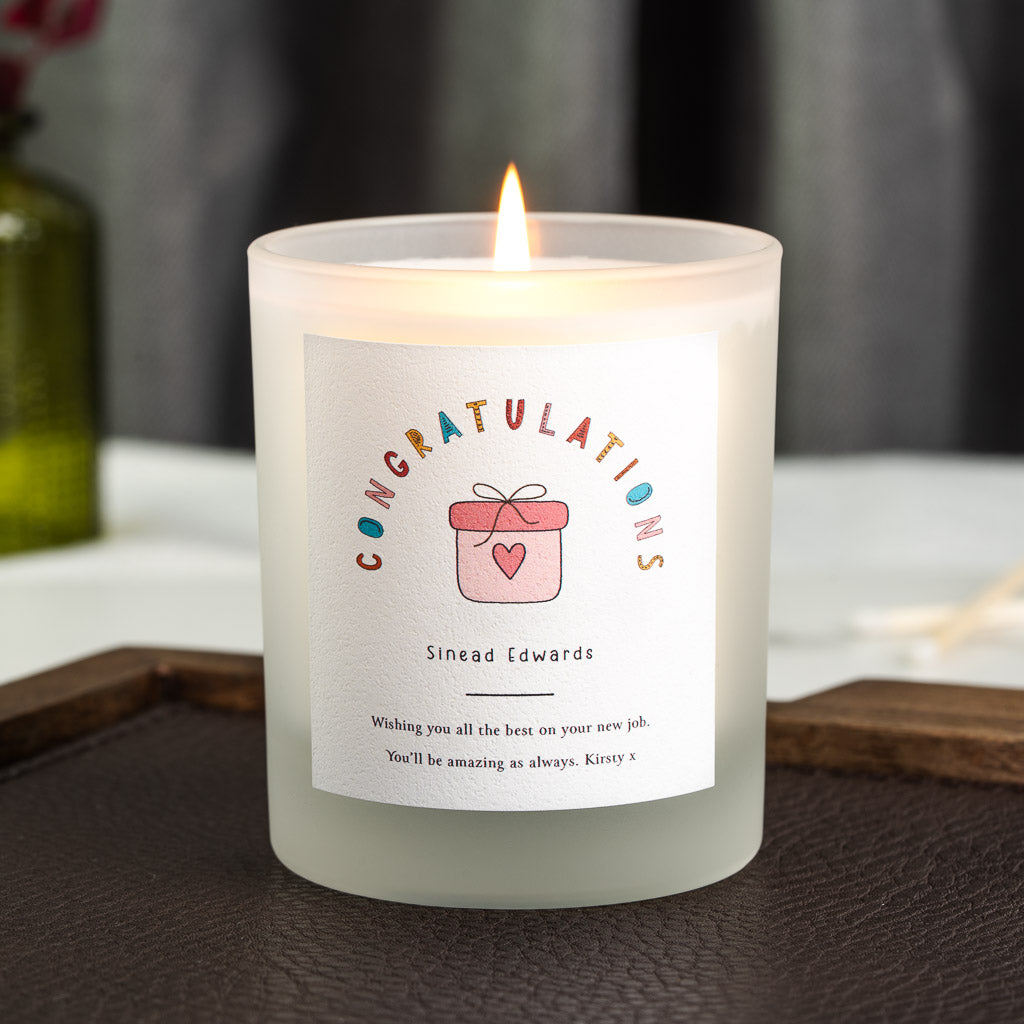 Personalised congratulations candle with individually coloured lettering above a gift box