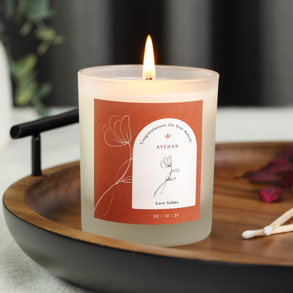 White arched panel on burnt orange with a curved heading on a personalised mehndi candle