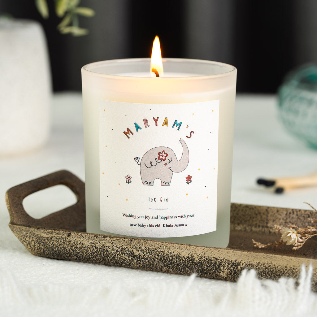 Grey elephant with a pink flower behind one ear on a personalised first Eid candle