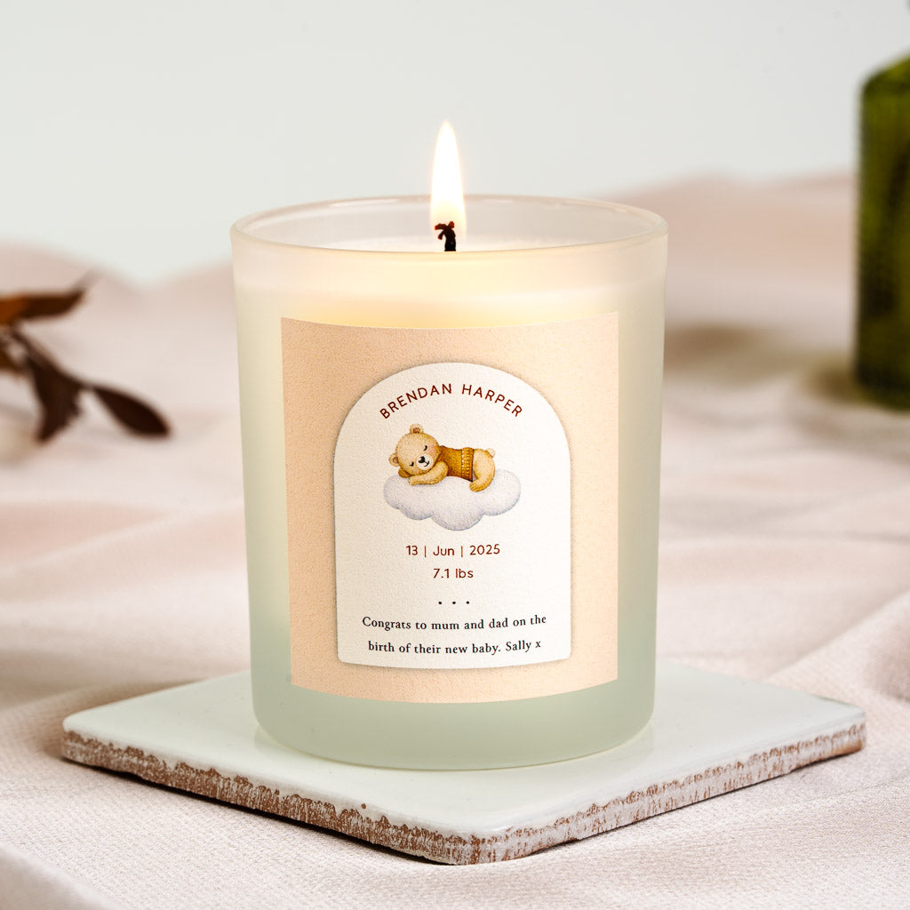Illustrated bear napping on a cloud inside a peach arch on a personalised new baby candle