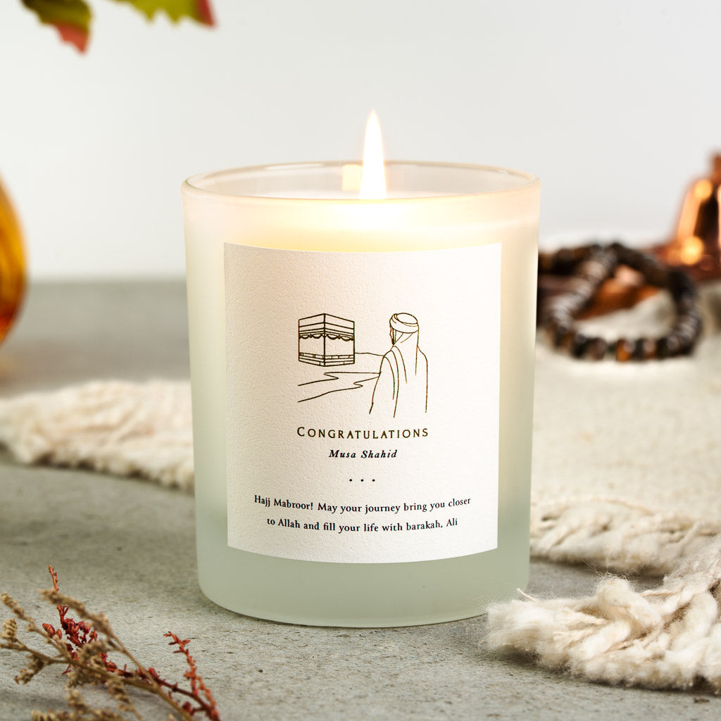 Personalised Hajj candle with a gold line drawing above congratulations in capitals