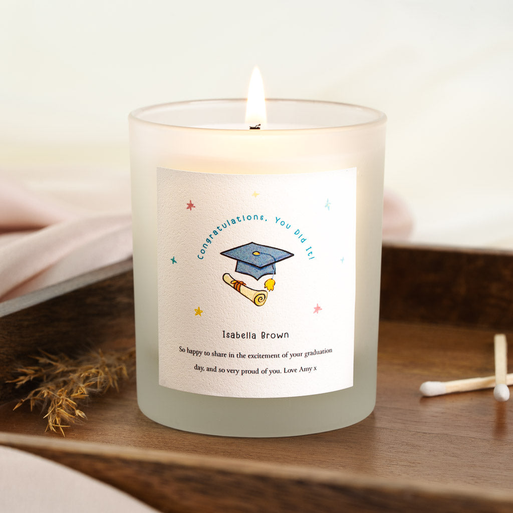 Blue graduation cap and rolled scroll beneath an arched heading on a personalised candle