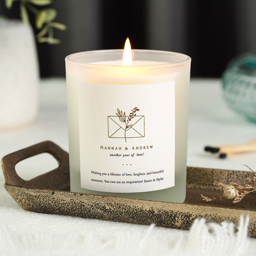 Botanical envelope illustration above the couple's names on a personalised anniversary candle