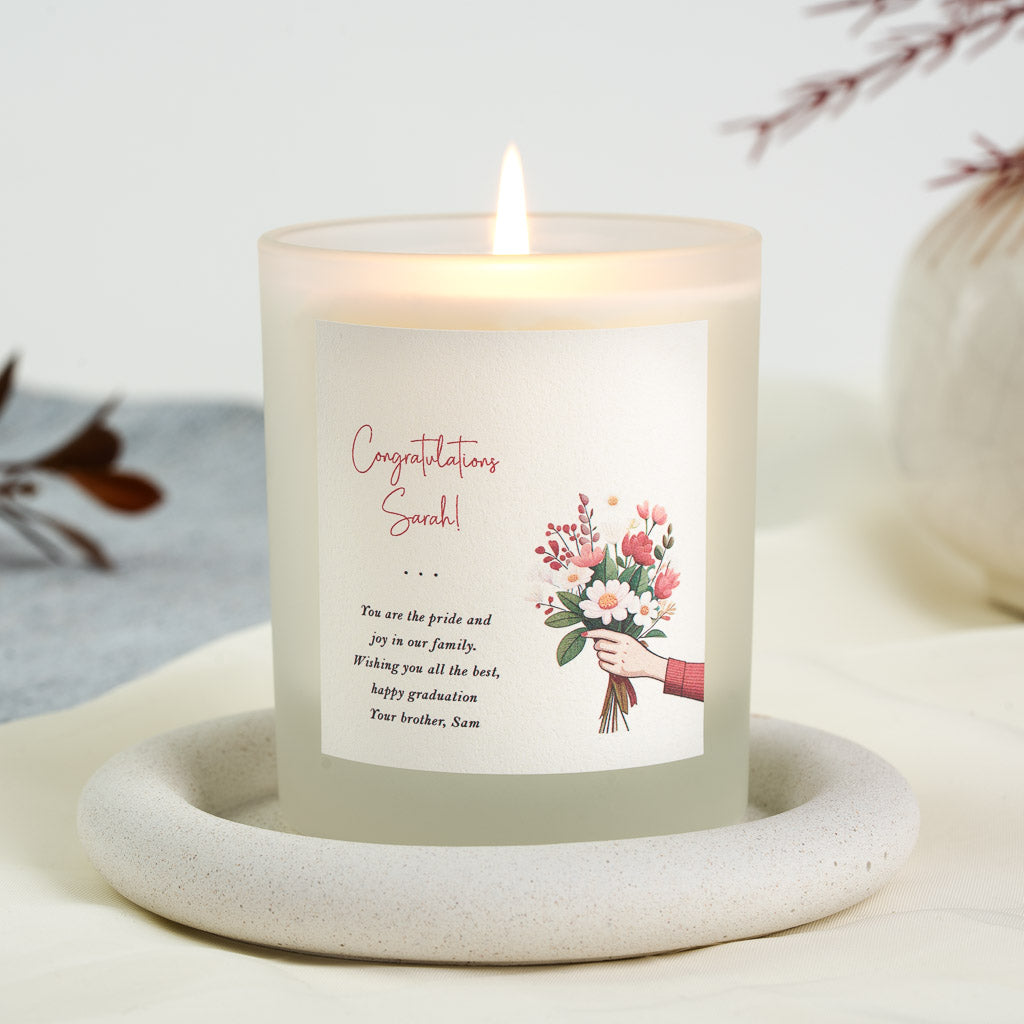 Illustrated arm holding a bouquet of pink and white blooms on a personalised graduation candle