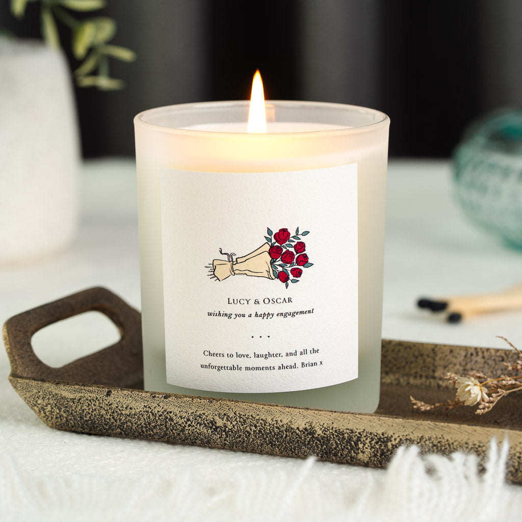 Personalised engagement candle with a bouquet illustration above italic script lettering